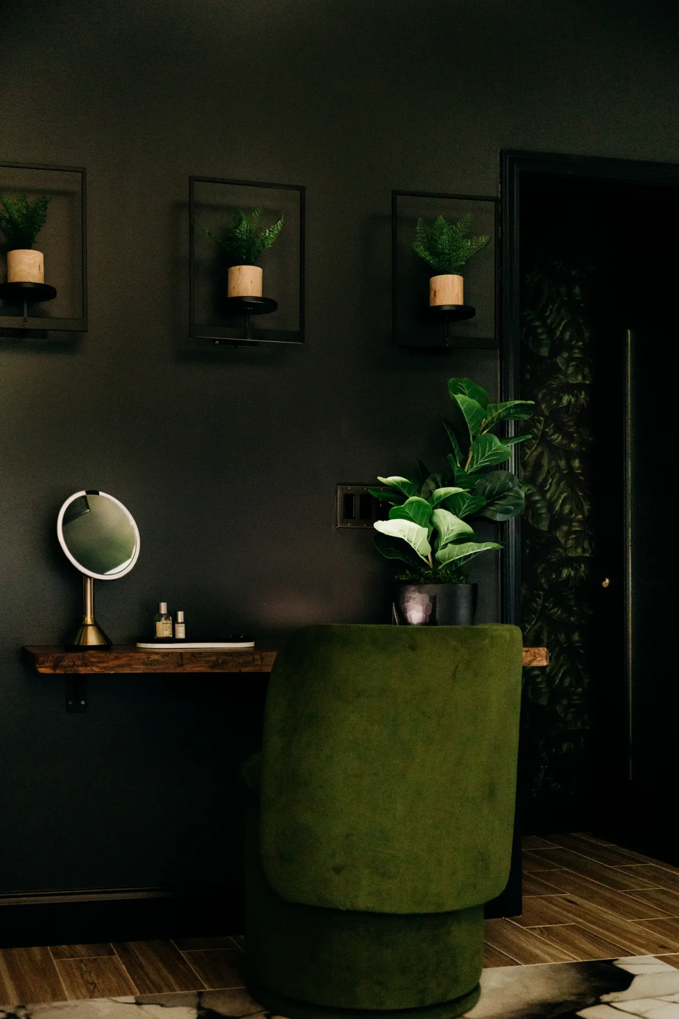 Green upholstered chair and floating dressing table in the primary bathroom.